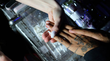 Close-up of a nail technician applying acrylic nails in a modern salon setting.